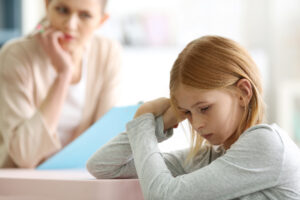 Sad teenager girl in child psychologist's office